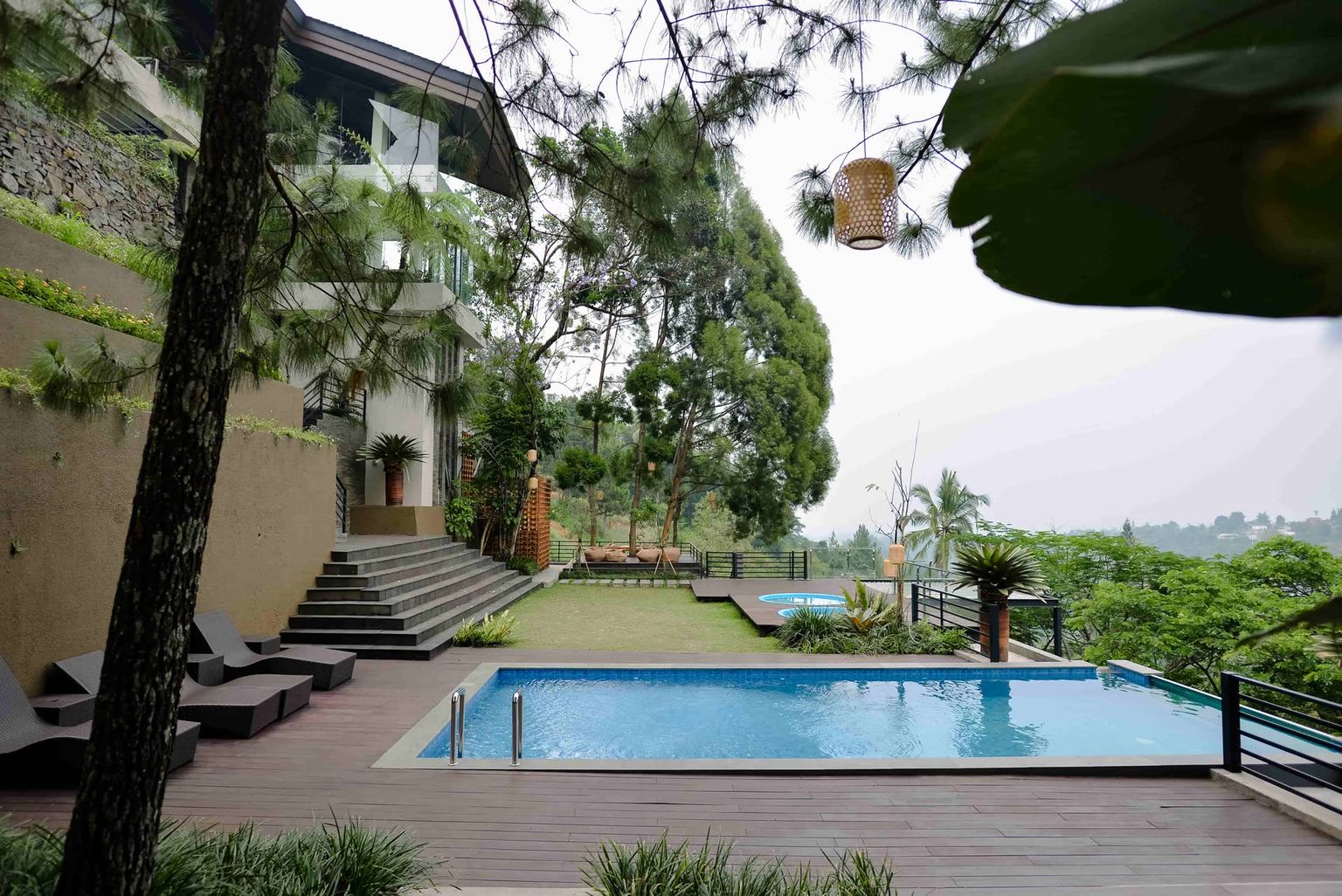 Kolam dan dek kayu vila VANA SHANKARA di antara pepohonan dan lembah