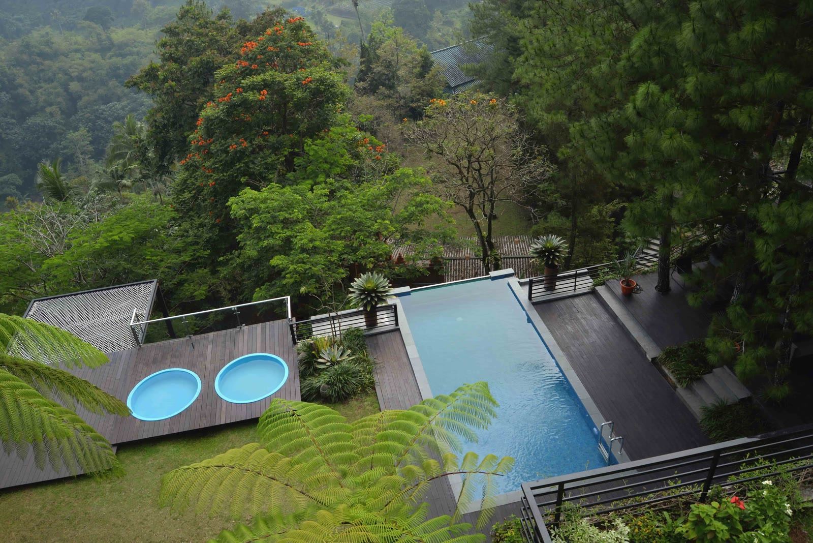 Kolam vila VANA SHANKARA dengan dek kayu, dikelilingi pohon dan lembah