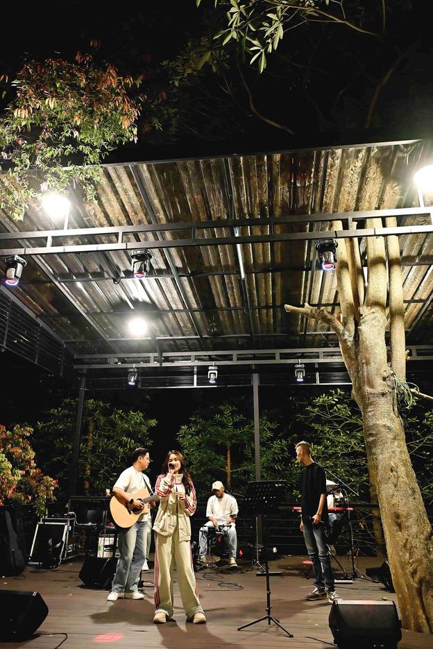 Gitaris dan penyanyi tampil di panggung VANA SHANKARA pada malam hari