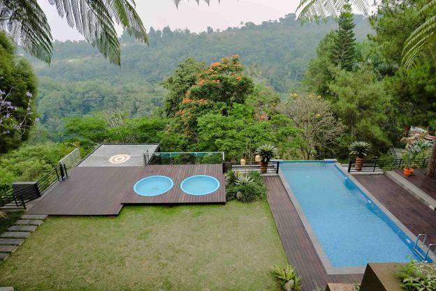 Halaman rumput VANA SHANKARA dengan infinity pool dan dua circle pool menghadap lembah