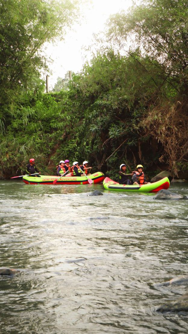 Peserta rafting mendayung perahu karet di sungai berbatu