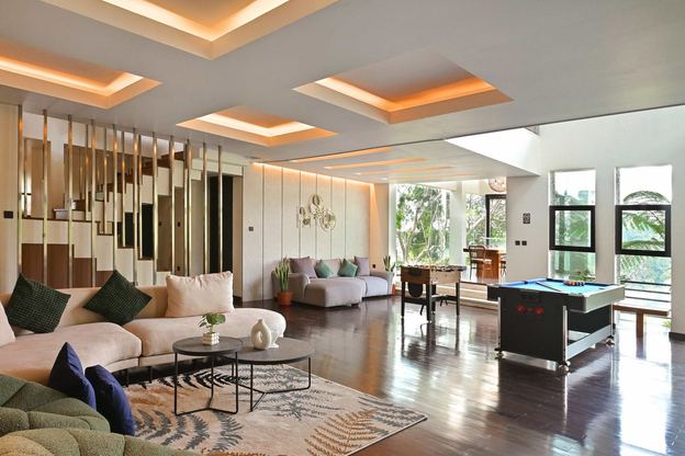 Ruang tamu vila dengan sofa dan meja biliar di lantai kayu