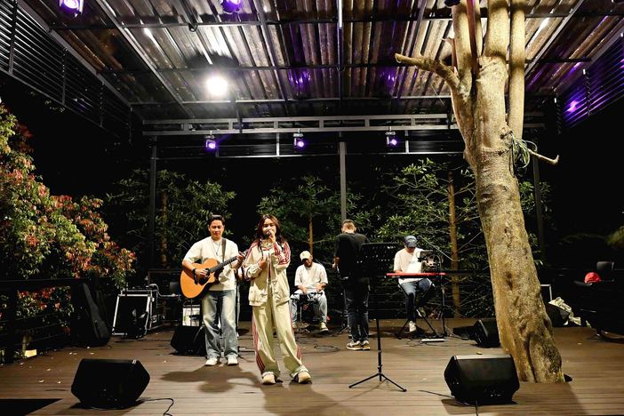 Band tampil di panggung terbuka VANA SHANKARA pada malam hari dengan lampu taman