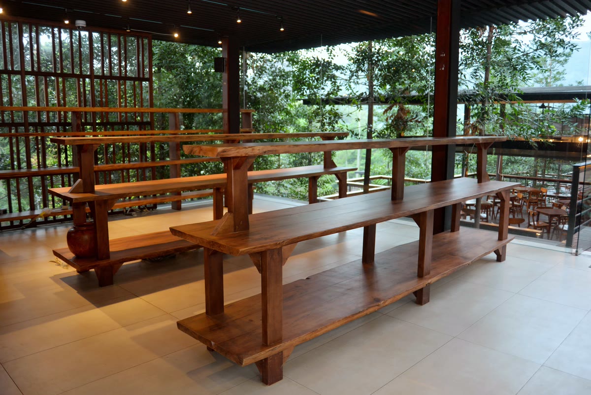 Meja komunal kayu panjang di ruang resto VANA SHANKARA