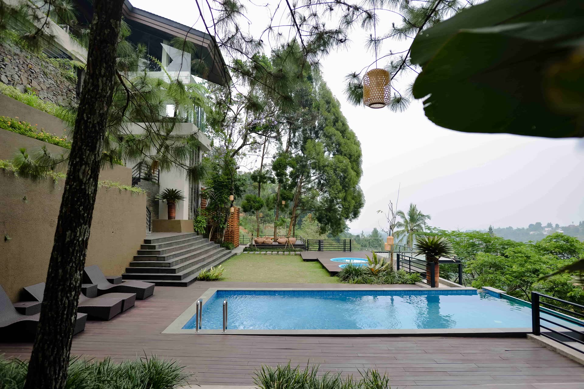 Kolam dan dek kayu vila VANA SHANKARA di antara pepohonan dan lembah