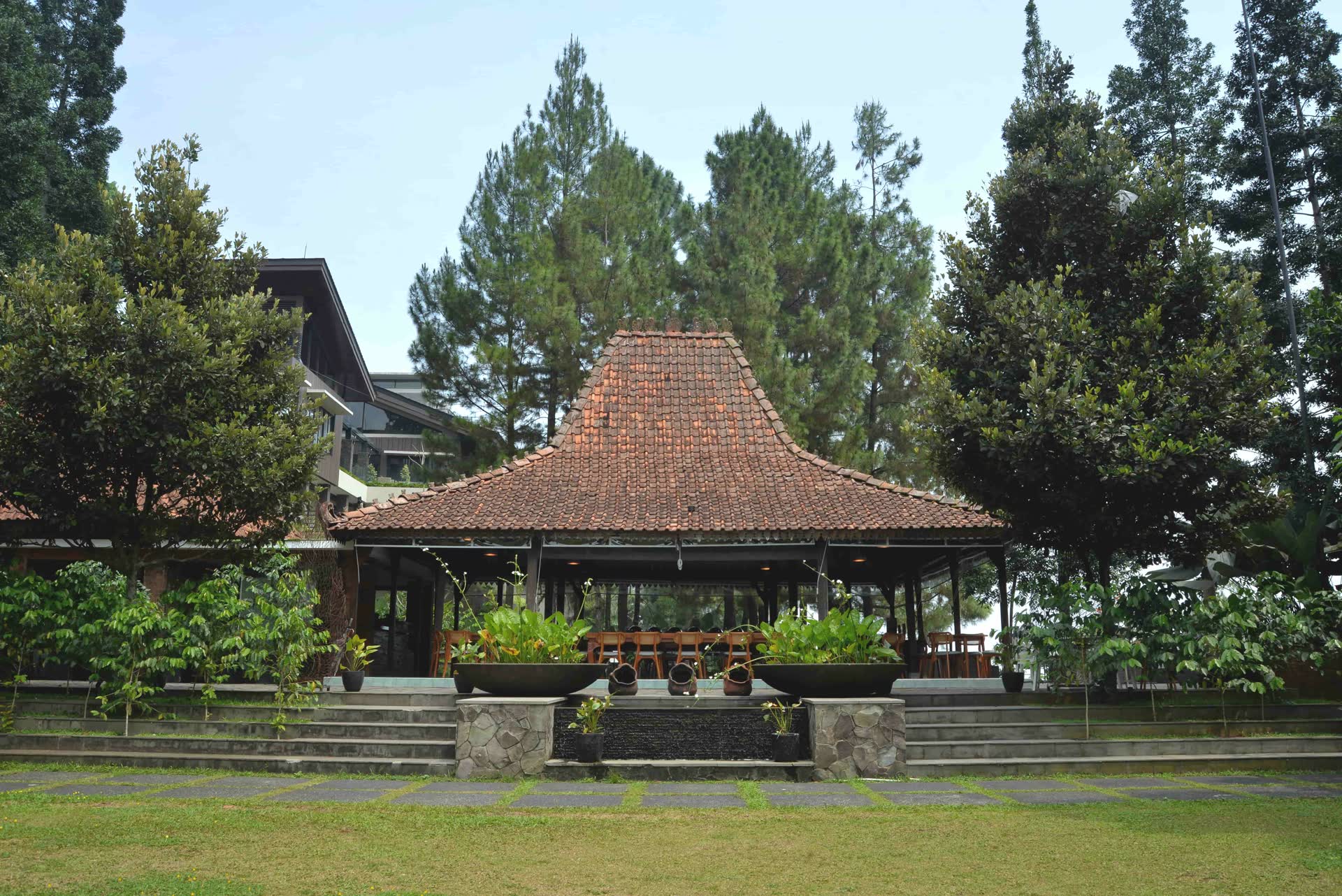Paviliun beratap sirap VANA SHANKARA di antara pepohonan dan halaman rumput